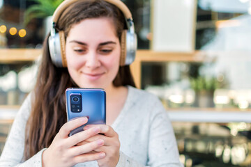 Young woman talking in video chat with her friend via smart phone.