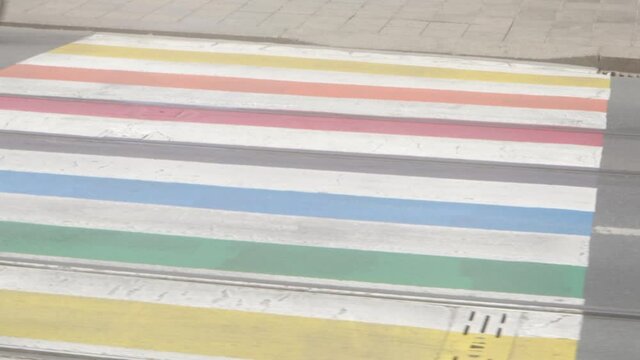 Panning Shot of a rainbow lgbtq pride cross walk in a city environment. Symbol of lgbtq+, gay, lesbian, transgender rights. Smooth hyperlapse 4K