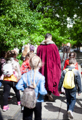 A guide in a historical costume conducts excursions for children