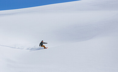 Snowboarder rides on fresh snow in winter against sky