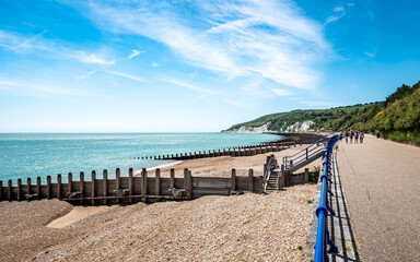 Eastbourne promenade and the South Downs, England. A bright, summer view of the beach west along the prom towards the white cliffs and South Downs.