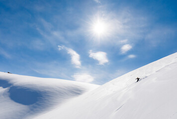 Skier rides on fresh snow against blue sky