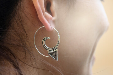 Girl wearing silver plated brass Indian earrings in spiral shape