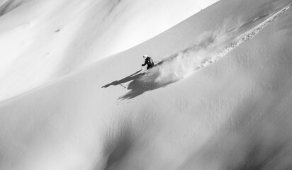 Skier rides on fresh snow black white
