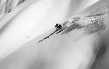 Skier rides on fresh snow black white