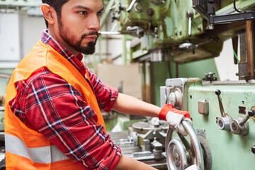 Maschinist an einer Maschine in einer Metallfabrik