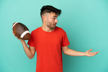 Young Caucasian man playing rugby isolated on blue background with surprise expression while looking side