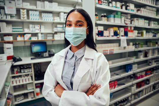 Happy Female Woman Working In Pharmacy Standing Behind Counter Wearing Labcoat And Covid-19 Face Protection Mask