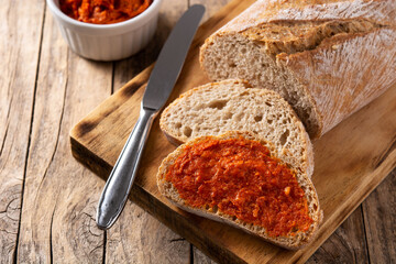 Sliced toast bread with sobrasada on rustic wooden table. Typical Mallorca food in Spain.	