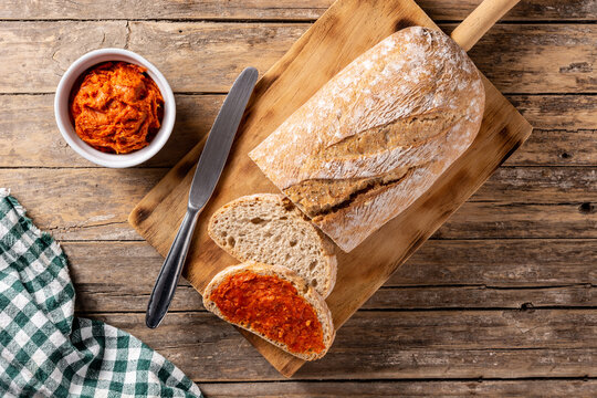 Sliced toast bread with sobrasada on rustic wooden table. Typical Mallorca food in Spain.	