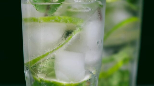 A refreshing soft drink. Mojito in a glass close-up. Lemon or lime, mint, and sparkling water with ice. cocktail, Party. Soda with lemon. Soda. Glass of alcoholic cocktail with rum, lime, mint