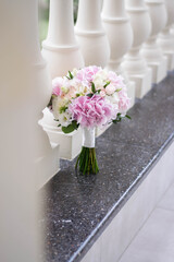 Beautiful bridal bouquet of white and pink flowers and greenery, on a gray textural background. Hydrangea wedding bouquet.