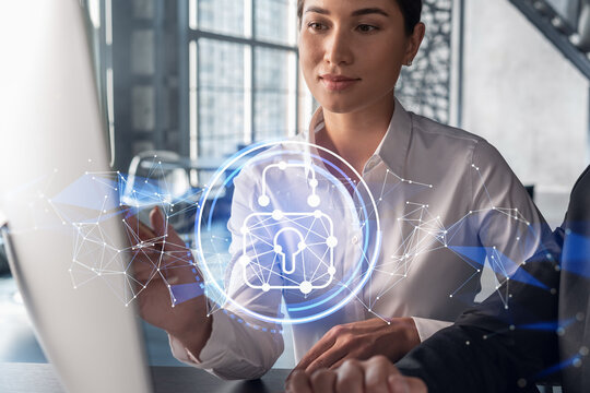 Businessman and businesswoman working together to protect clients confidential information and cyber security. IT hologram padlock icons over office background with panoramic windows.