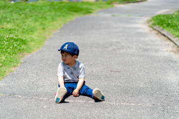 Fototapeta premium 道路で座り込む男の子