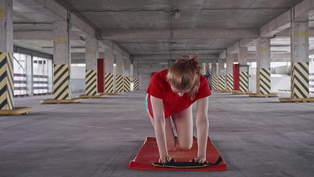 Young girls does fire hydrate exercise then stands up and stretches posterior of hamstrings. Outdoor traning. front view.