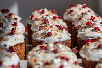 Delicious easter cakes with sprinkles and frosting. Easter cakes decorated with sweet sugar icing, dried little rose flowers and almond roasted flakes