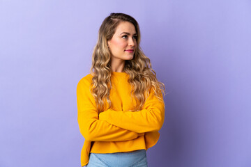 Fototapeta premium Young Brazilian woman isolated on purple background looking to the side