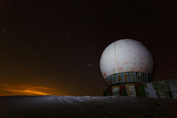 Meteo station and starry sky in the mountains in winter