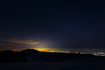 View of the night city from the mountains in winter