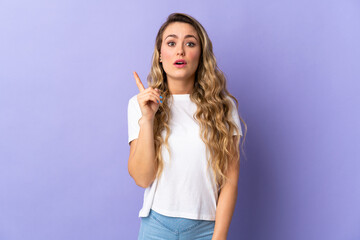 Obraz premium Young Brazilian woman isolated on purple background intending to realizes the solution while lifting a finger up