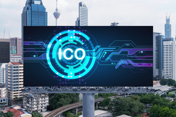ICO hologram icon on billboard over panorama city view of Kuala Lumpur at day time. KL is the hub of blockchain projects in Malaysia, Asia. The concept of initial coin offering, decentralized finance