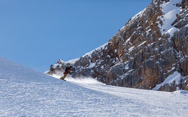 Snowboarder rides on snow in the mountains in winter for heliskiing