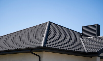 Brown corrugated metal profile roof installed on a modern house. The roof of corrugated sheet. Roofing of metal profile wavy shape. Modern roof made of metal. Metal roofing.