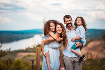 Fototapeta na wymiar Happy family. Portrait of the smiling family standing in the vineyard.