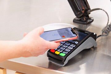 Woman's hand pays for a purchase using her phone