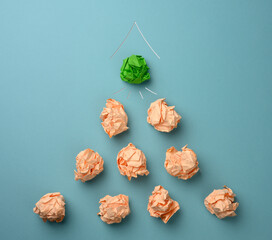 crumpled sheets of colored paper on a blue background. Solution concept, brainstorming, leap forward