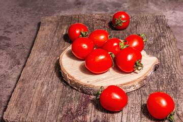 Red cherry tomatoes on a wooden stand