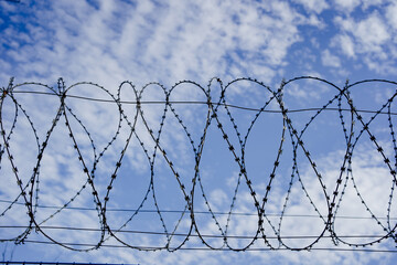 barbed wire against the blue sky. protected area. A special, dangerous zone.