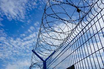 barbed wire against the blue sky. protected area. A special, dangerous zone.