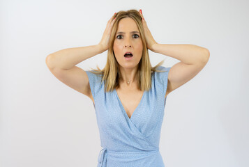 Young woman hold hands on head, open mouth with casual dress isolated over white background