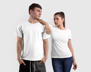 Fototapeta premium Mockup of a white t-shirt on a girl and a guy, isolated on background in the studio, clothes for design, front view set