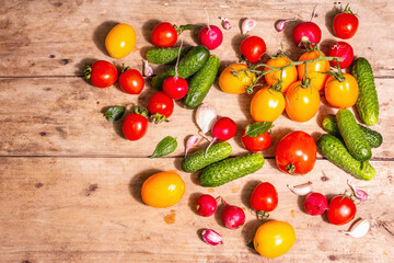 Naklejka na ściany i meble Assortment of ripe organic farmer red and yellow tomatoes, cucumbers, radish, garlic, and fresh basil leaves