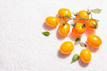 Yellow-orange tomatoes on light plaster background
