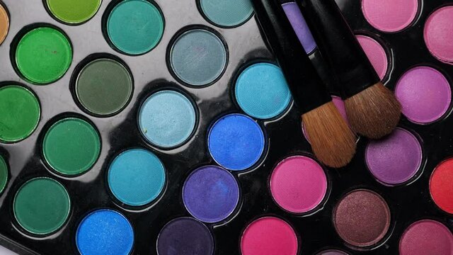 Professional makeup eyeshadows palette and brushes for make-up artist, closeup. Rotation