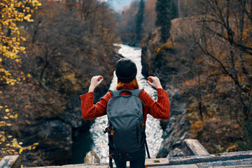cheerful woman Tourist of all the law admires the nature of the mountain river