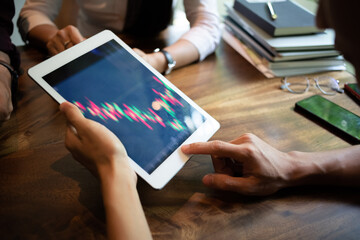 Businessman holding tablet pointing and look directions change Average line Share price movement Stock trading in the up and down on the display