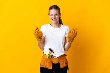 Young electrician woman isolated on yellow background making money gesture