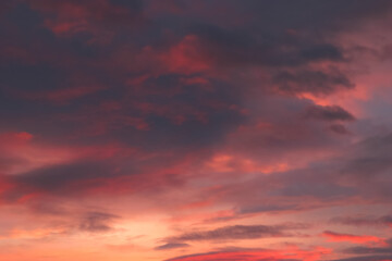 灰色の雲に反射する夕焼けの朱色