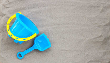 Fototapeta na wymiar Plastic toys, shovel and bucket on sand