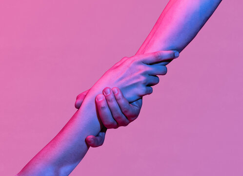 Hands of a man and a woman are connected by a handshake. Metaphor of rescue, love, assistance.