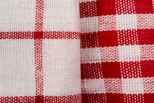 Pile of checkered fabric closeup kitchen towels folded on background, macro flat lay image