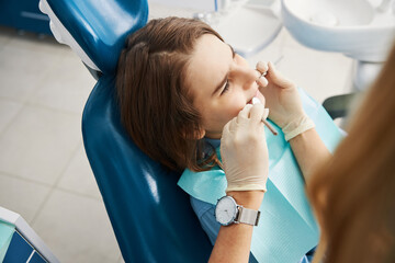 Underage patient is undergoing teeth care procedure