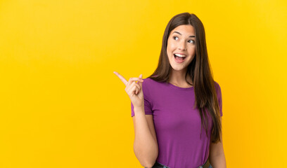 Teenager Brazilian girl over isolated yellow background intending to realizes the solution while lifting a finger up