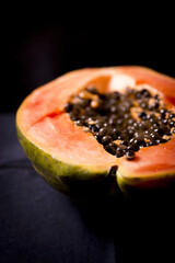 Half of an open papaya with the seeds