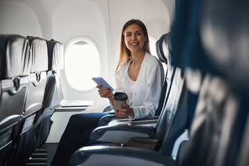 Contented female passenger of the airplane sitting alone