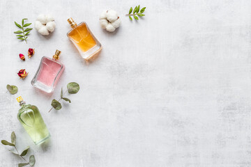 Perfume bottles flat lay with flowers and leaves, top view